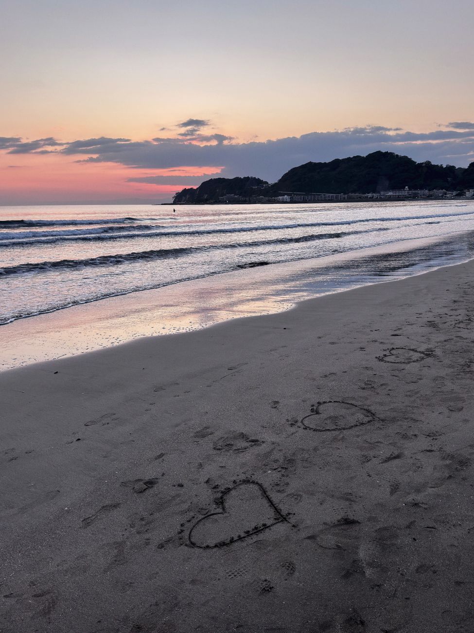 romantic sunset beach with heart drawings